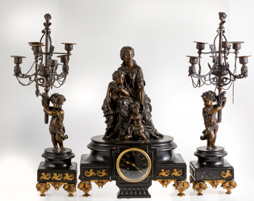 Guarnición en mármol negro y bronce, compuesta por reloj y 