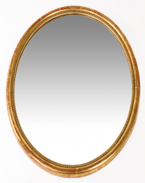 Espejo ovalado con marco de madera tallada y dorada, pps.S.