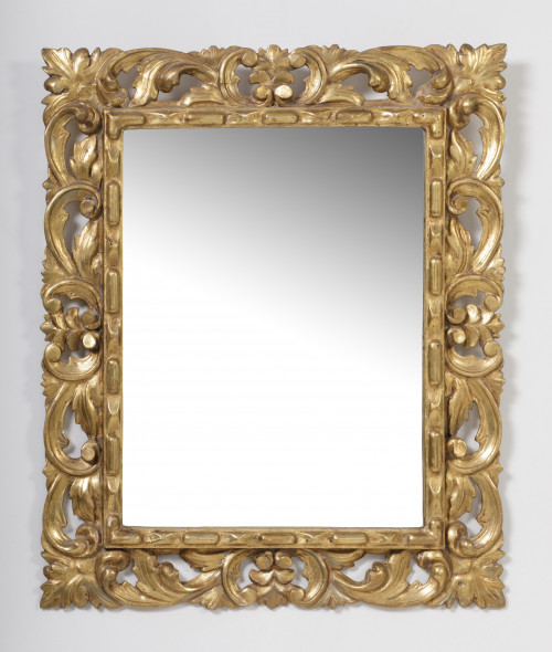 Espejo de madera tallada, calada, estucada y dorada siguien