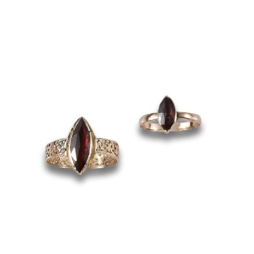 SET OF TWO RINGS IN LOW GOLD AND GARNETS